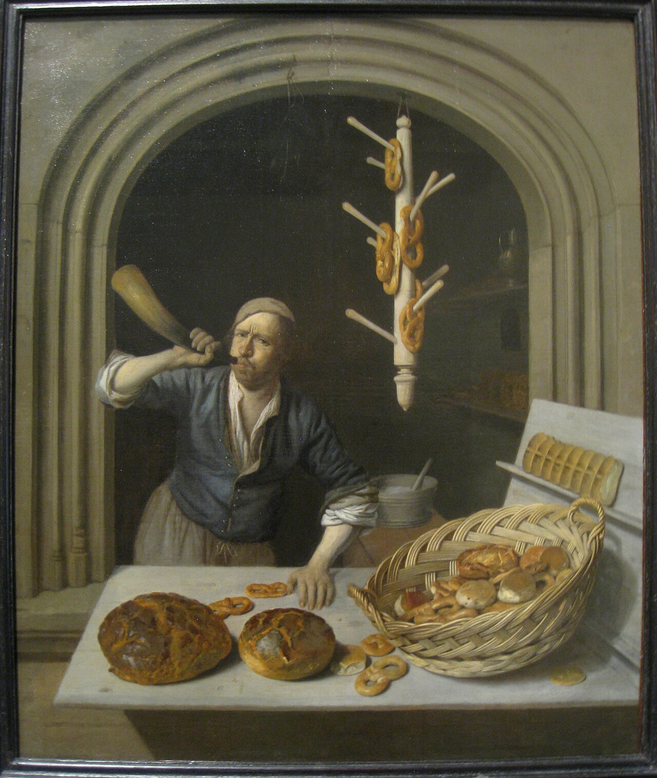 Painting of a baker at his counter with bread and pretzels